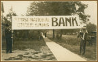 Postcard of a banner advertising 1st National Bank