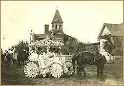 1910 Flower Parade entry with High School in background